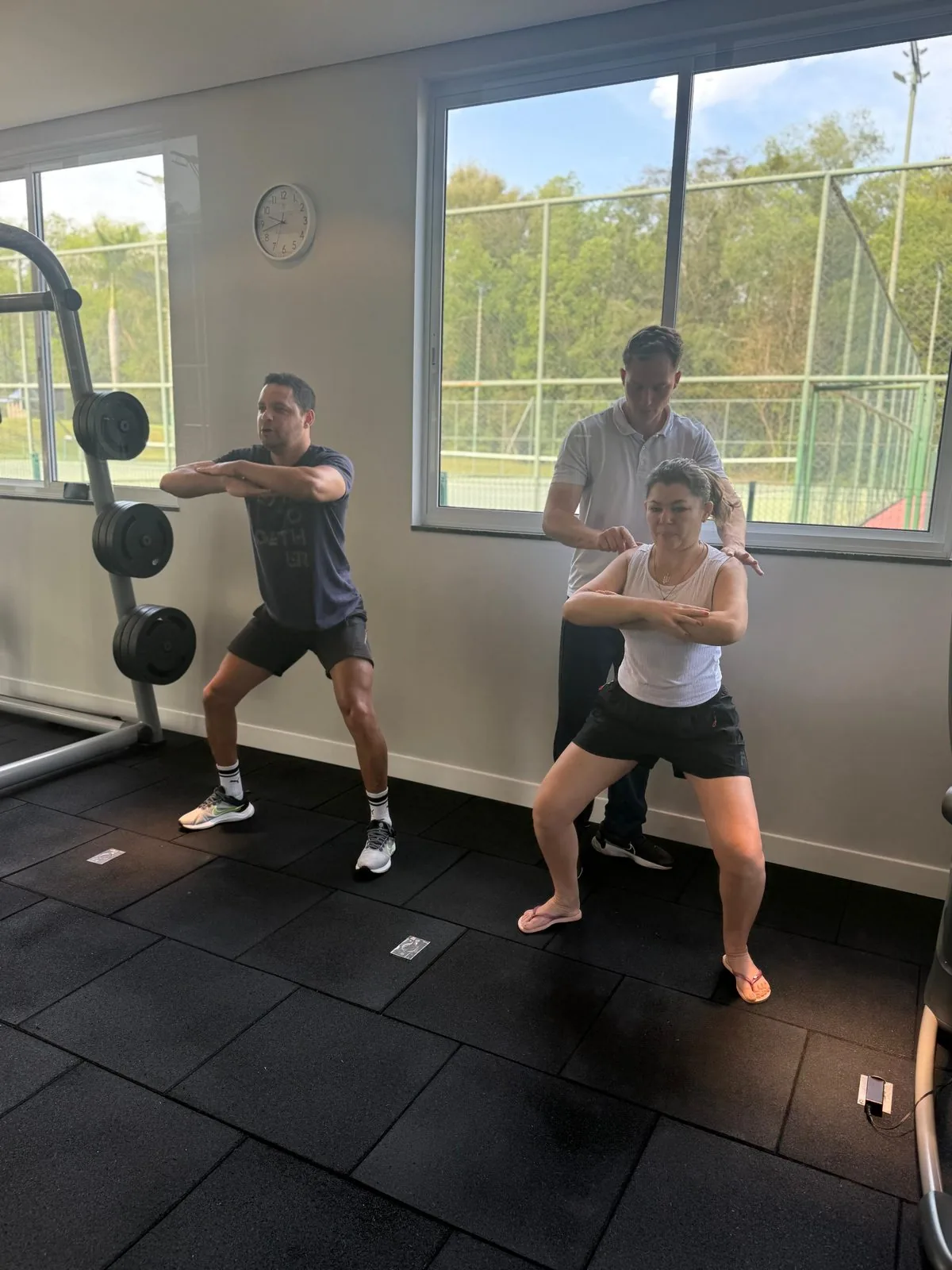 Duas pessoas treinando em um espaço com equipamentos